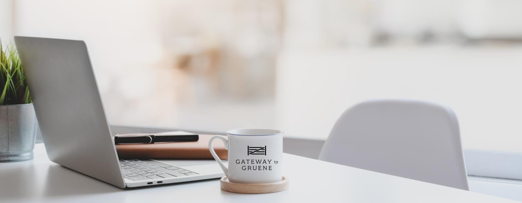 a coffee cup and a laptop on a table